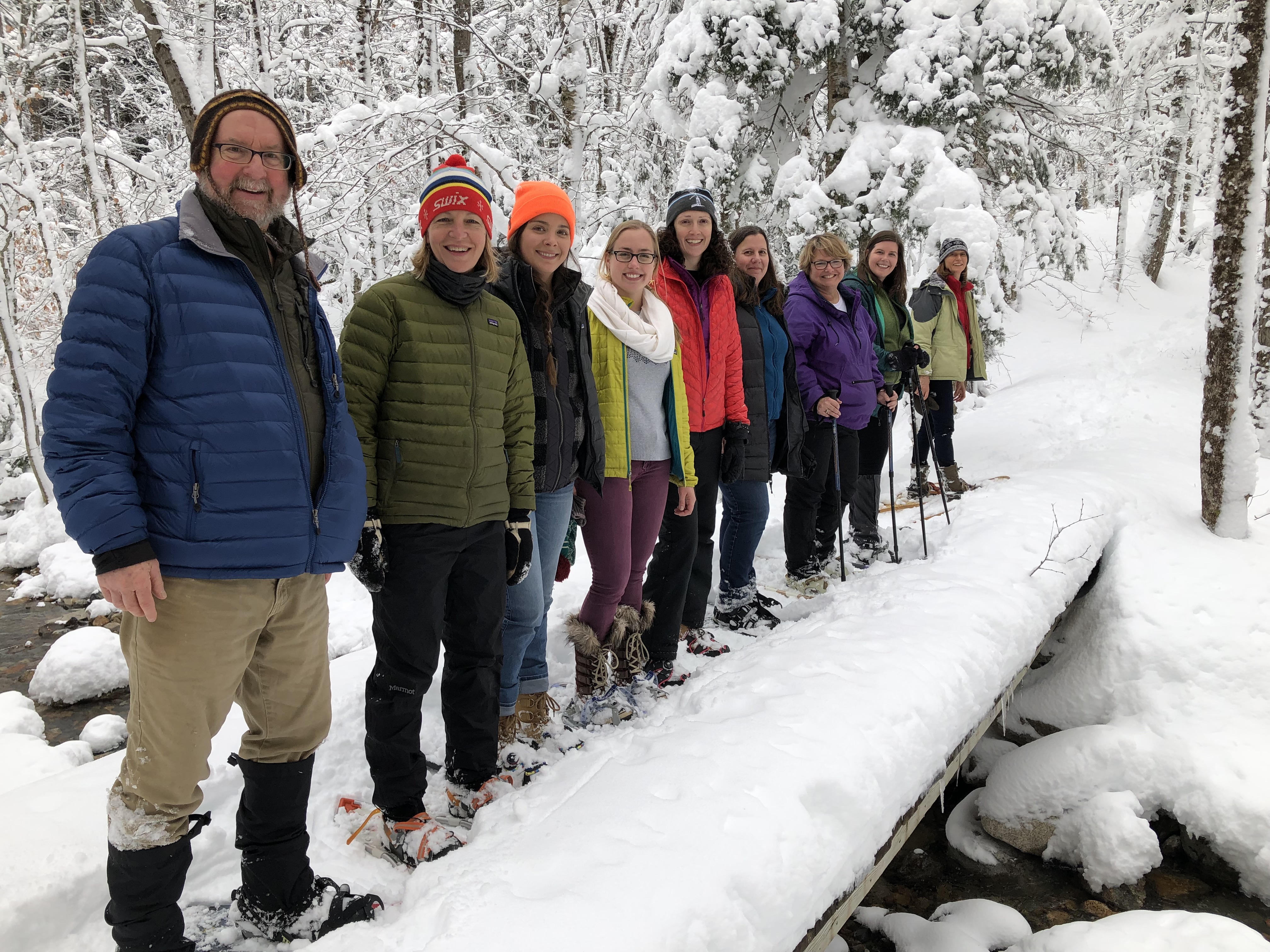 A group of people looking at the camera during a winter hike.