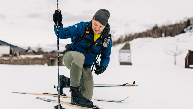 smiling volunteer measuring snow