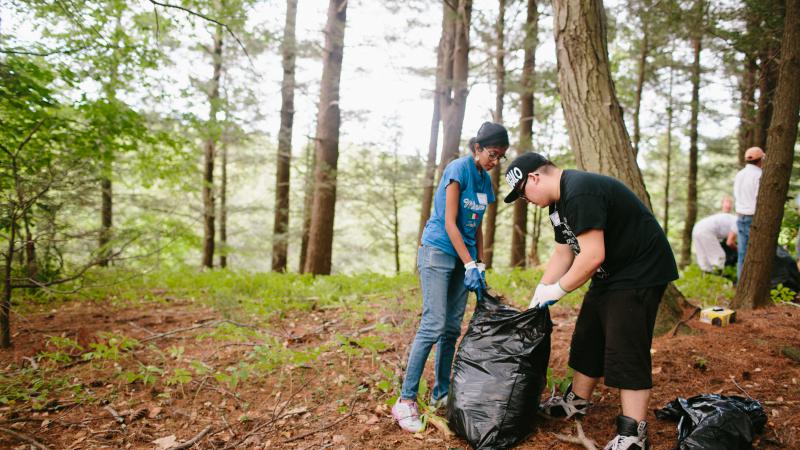 volunteers putting litter in a trash bag