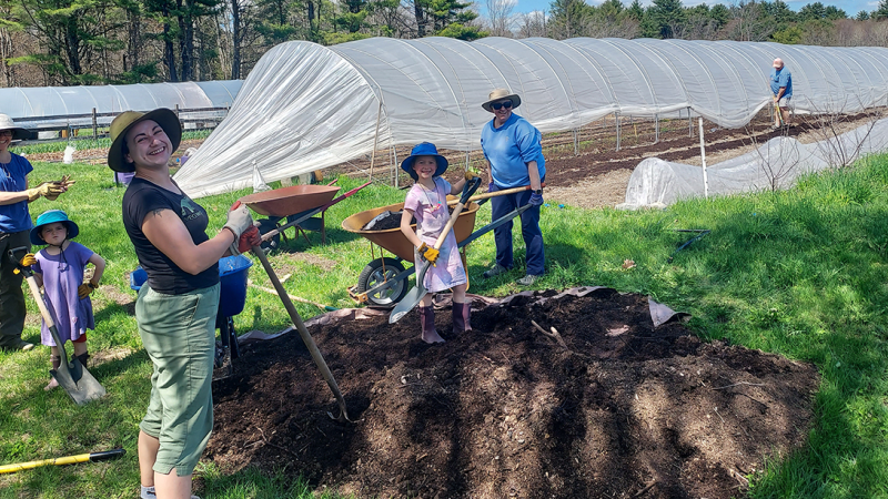 smiling volunteers near garden beds