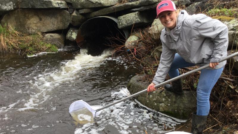 Volunteer holding a net in a stream