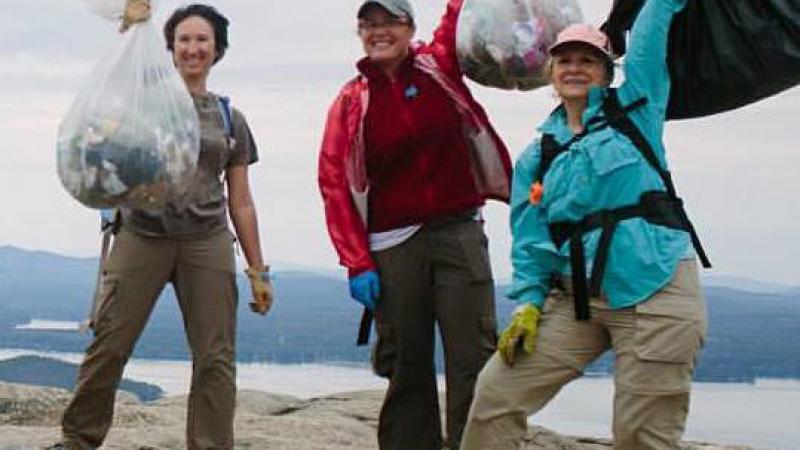 volunteers holding trash bags on top of Mt. Major