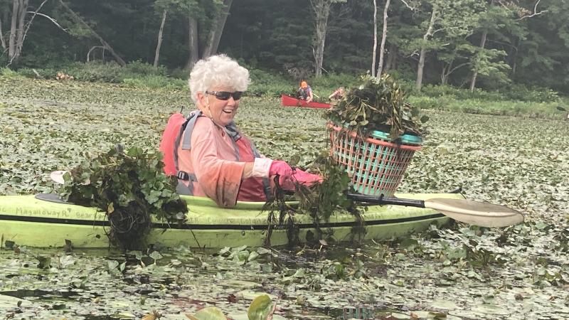 volunteer smiling holding pulled water chesnut