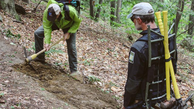 Volunteers working with tools on trail