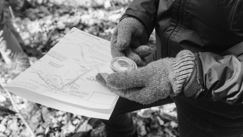 hand holding a compass and property map