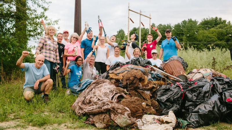 group of volunteer smiling with cleaned up trash