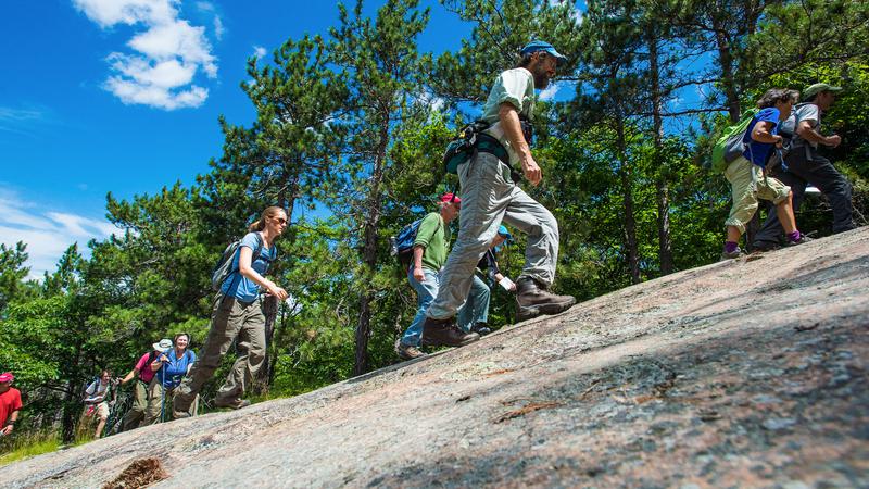 hikers walking on large boulder