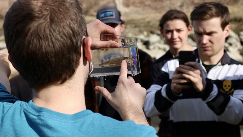 volunteer holding up rainbow smelt