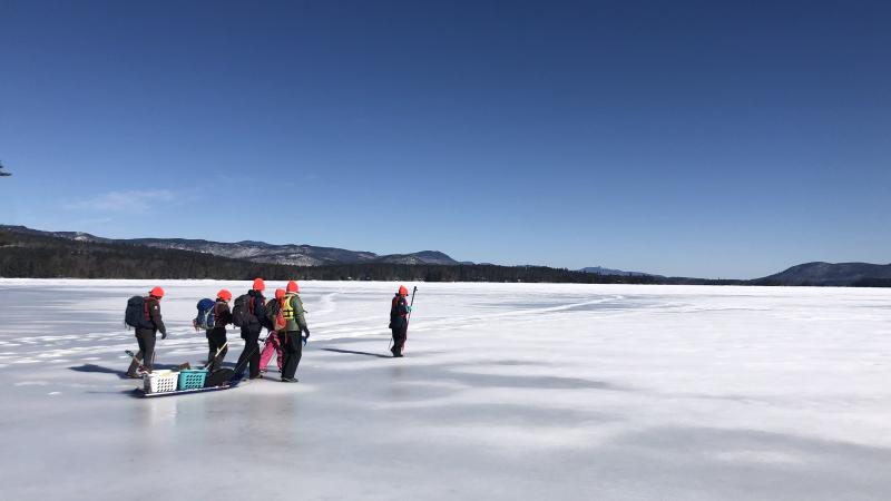 people walking out on frozen lake