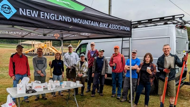 trail volunteers standing around tent