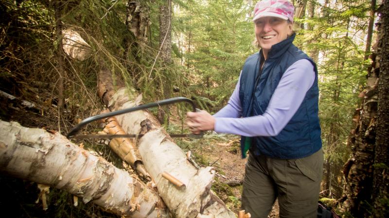 Volunteer using hand saw