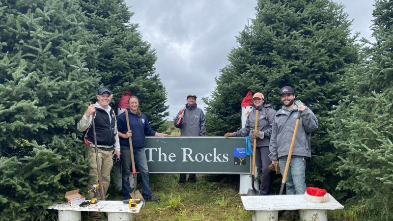 group of smiling volunteers with tools.