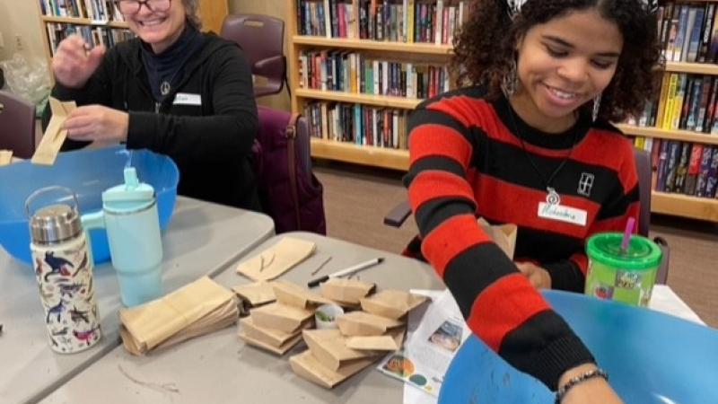 two volunteers packing seeds