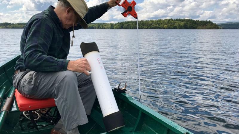 Volunteer taking water samples on lake