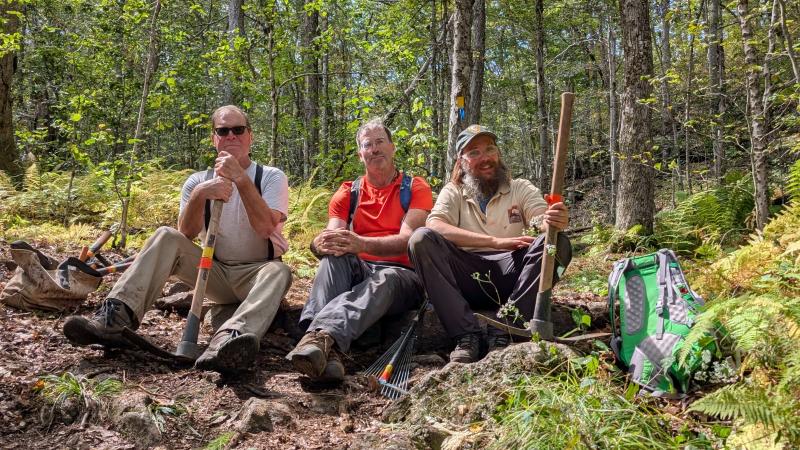 people smiling sitting on trail