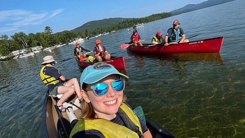 smiling volunteers in canoes
