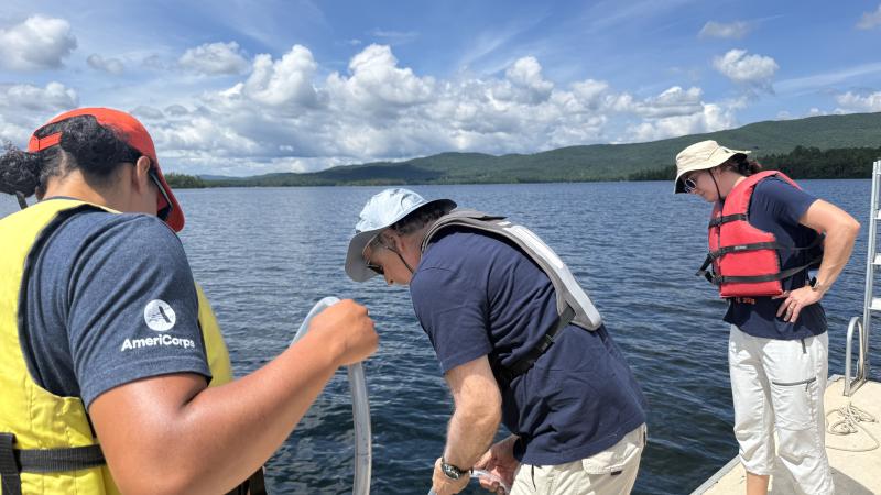 people standing on boat collecting water samples