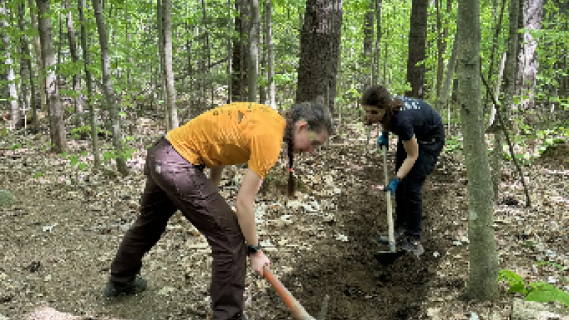 person using tool for trail work