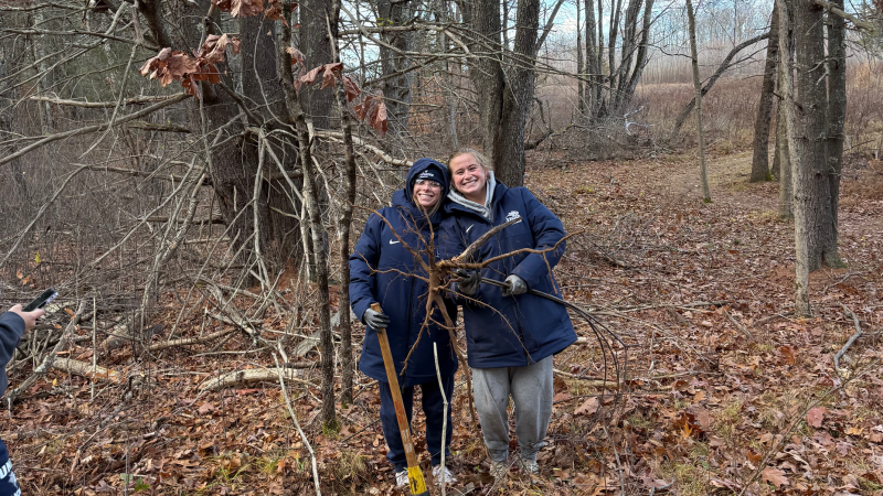 two volunteers holding buckthorn