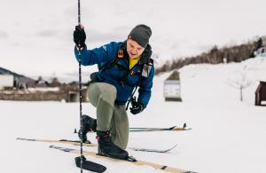 smiling volunteer measuring snow
