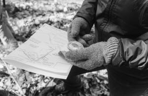 hand holding a compass and property map