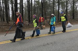volunteers walking on road picking up trash