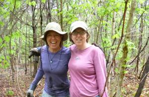 Two volunteers working in the woods.