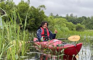 volunteer in kayak on lake smiling