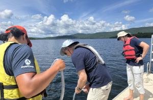people standing on boat collecting water samples