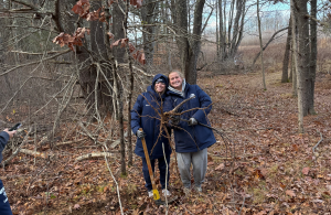 two volunteers holding buckthorn