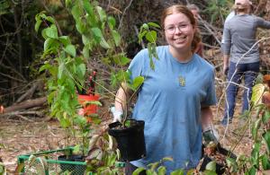 person smiling holding plant