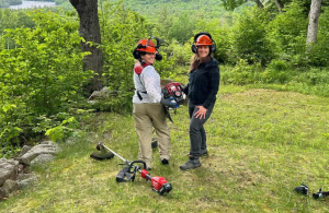 two volunteers with weed wrackers