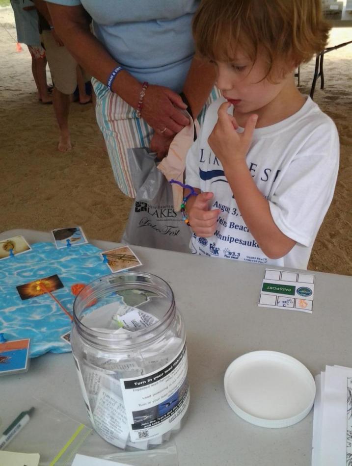youngster ponders the food web in the Watershed Warriors tent