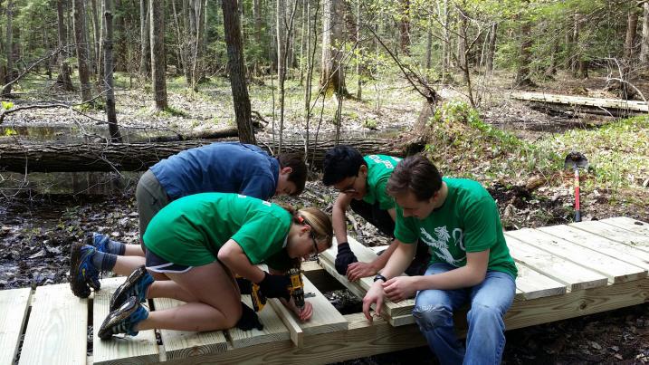 volunteers building a trail bridge