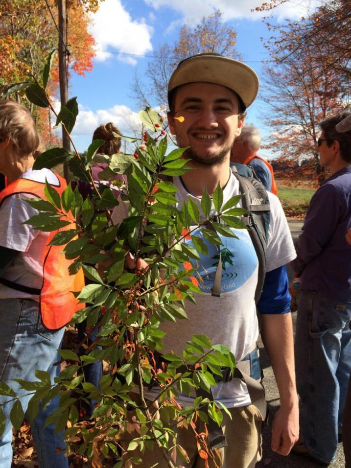 Smiling volunteer holding invasive plants