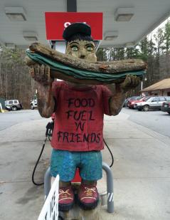 gas station statue holding a sandwich