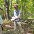 person showing book to volunteers on trail
