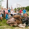 group of volunteer smiling with cleaned up trash