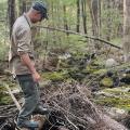 person standing in stream with woody material