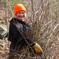 person holding pile of pulled invasive plants