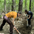 person using tool for trail work