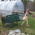 child pulling a cart in a garden