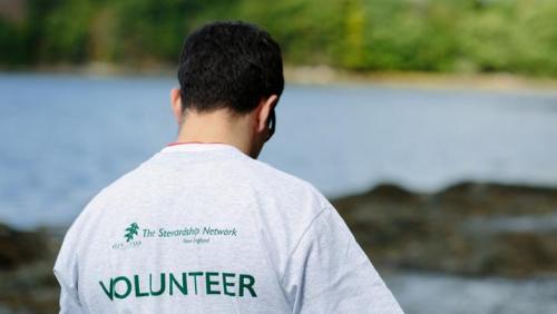 Volunteer shirt guy next to water